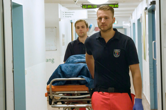 Zwei Notfallsanitäter bringen einen Patienten ins Krankenhaus