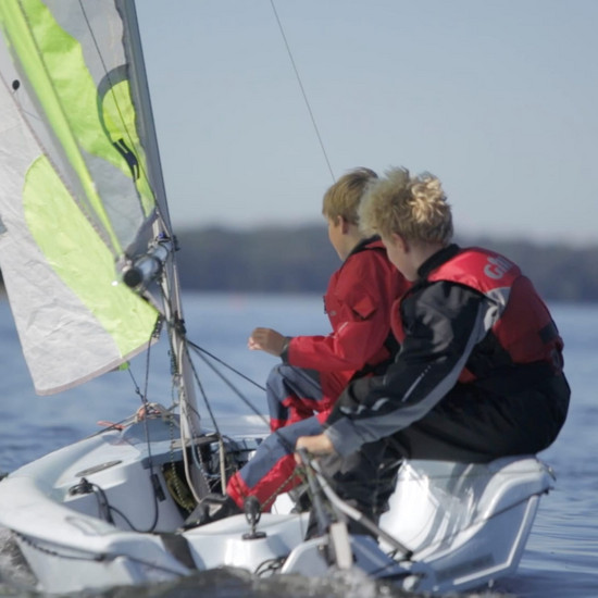 Zwei Kinder segeln in einem kleinem Boot