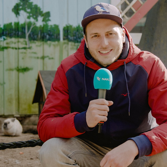 Ostergrüße von Lars 2019 Lars sitzt vor einem Kaninchengehege