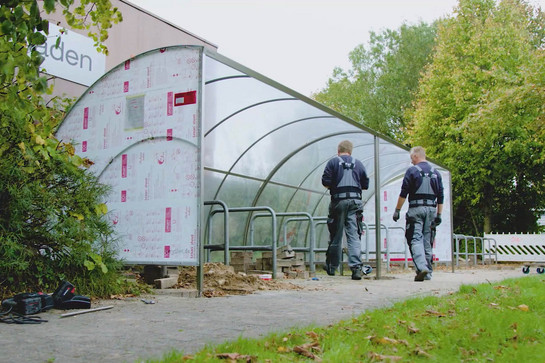 Zwei Bauarbeiter renovieren einen Fahrradständer