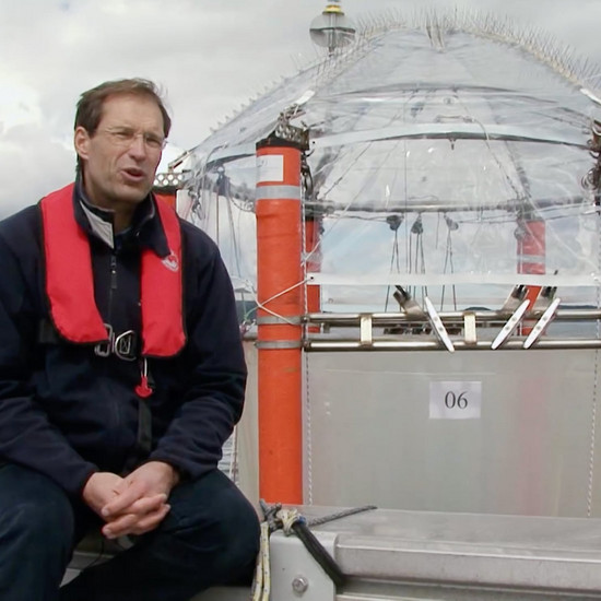 Ein Mann in Rettungsweste sitzt auf einem Boot