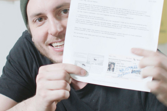 Lars hält ein Stück Papier in die Kamera