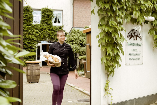 Anna Bandholt trägt einen Korb mit Brötchen