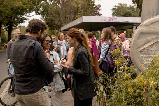 Eine Summer School Klasse steht an einer Bushaltestelle