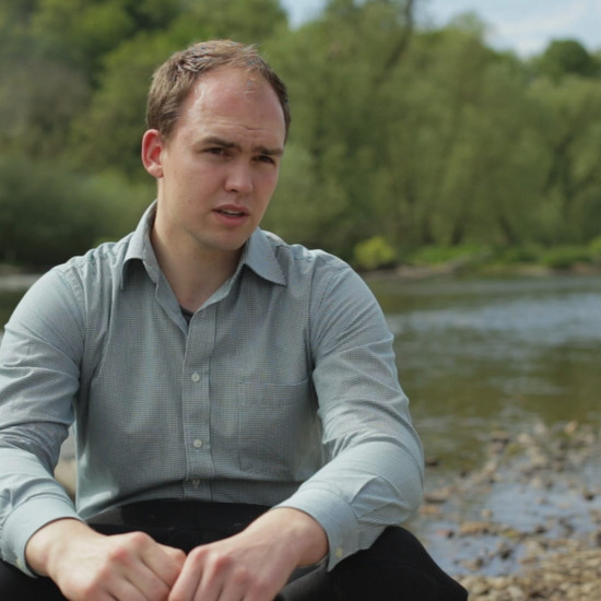 Ein Mann sitzt an einem Fluss