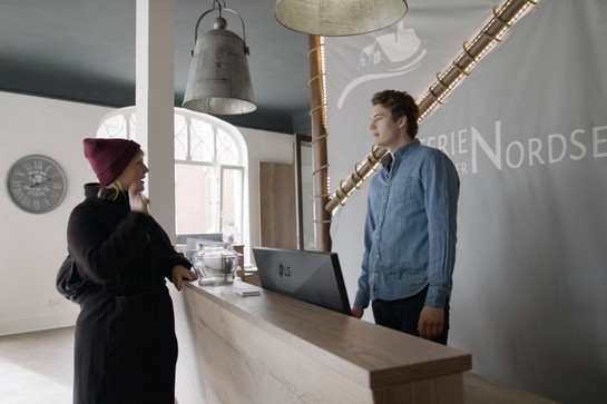 Eine blonde Frau steht an einer Rezeption