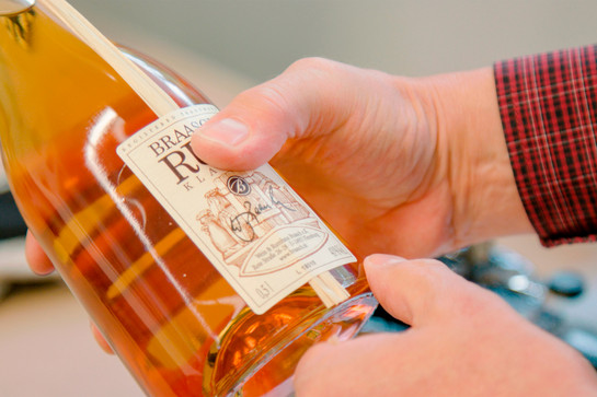 Eine Person hält eine Flasche Braasch Rum