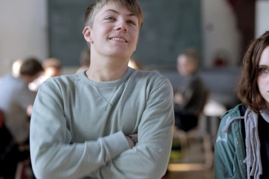 Ein blonder Junge verschränkt die Arme