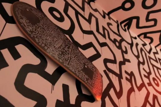 Ein schwarzes Skateboard hängt an der Wand