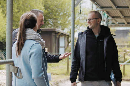 Jens Schaarschmidt spricht mit einem Paar vor dem Rohbau.