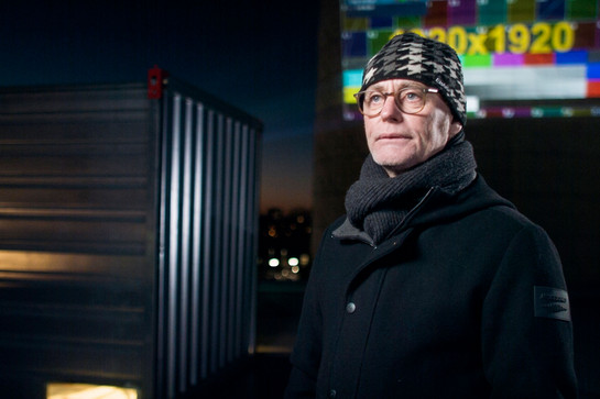 Mann mit Brille und Mütze im Interview