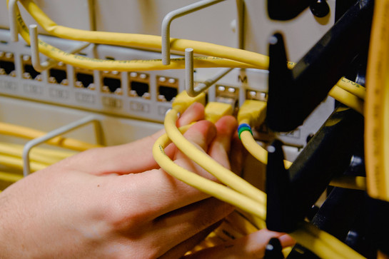Eine Person schließt ein gelbes Kabel an