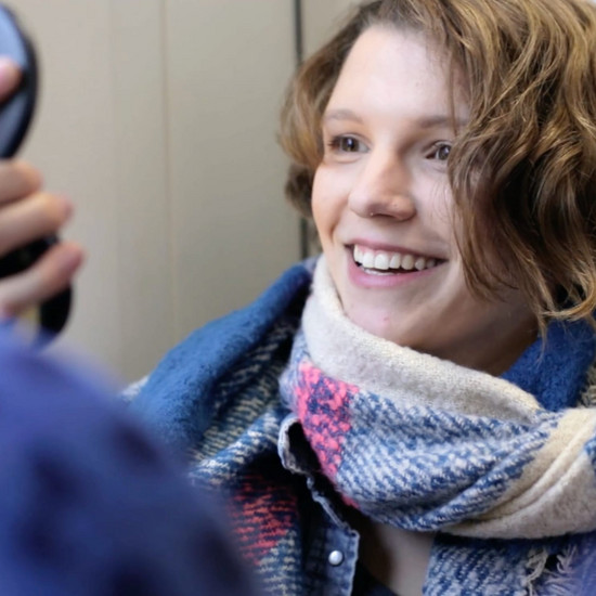 Video über das Speedcuben im Personennahverkehr Eine Frau sitzt im Zug und guck sich in den Spiegel