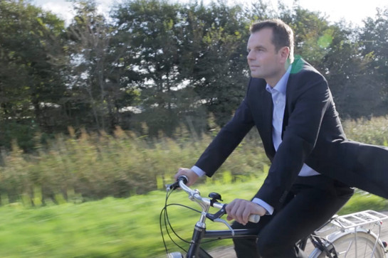 Ein Mann im Anzug fährt Fahrrad