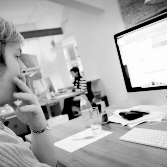 Ein Mann guckt nachdenklich auf seinen Apple Computer