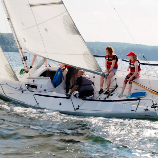 Zwei Mädchen sitzen auf einem Segelboot