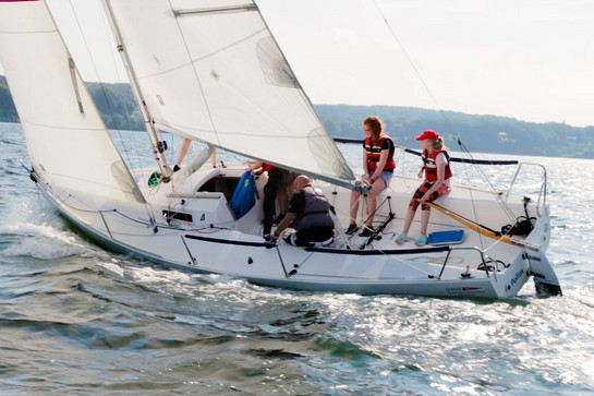 Zwei Mädchen sitzen auf einem Segelboot