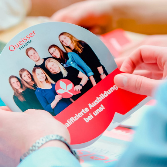 Eine Person hält eine Karte der Queisser Firma