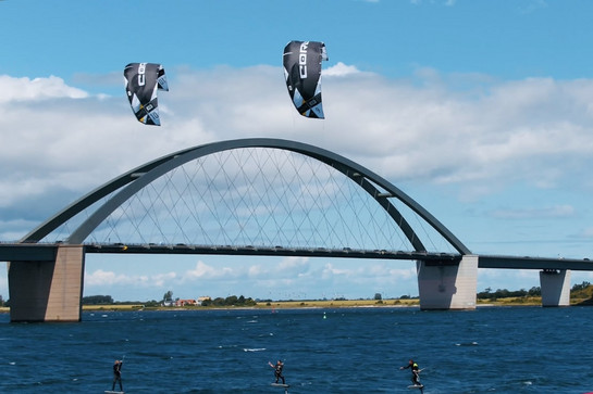 Drei Kiter kiten in der Nähe der Hansebelt