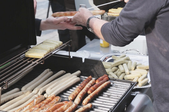 Blick auf einen Grill voller Würstchen