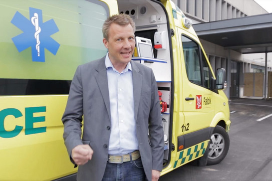 bb_wachstumszentrum_teaser_05_hauptteaser.jpg Ein Mann steht vor einem gelben Krankenwagen