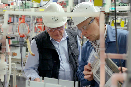 Zwei Männer gucken sich ein Behälter in der Chlorproduktion an