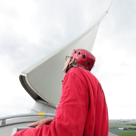 Jubiläumsfilm für Messe Ein Mann trägt einen roten Arbeitsanzug