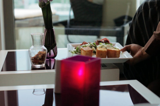 Nahaufnahme, eine Servicekraft stellt einen Teller mit Essen auf den Tisch.
