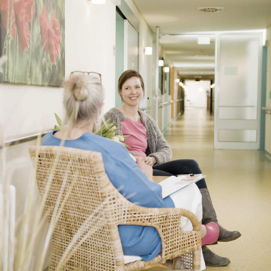 Zwei Frauen sitzen im Flur der Entbindungsstation