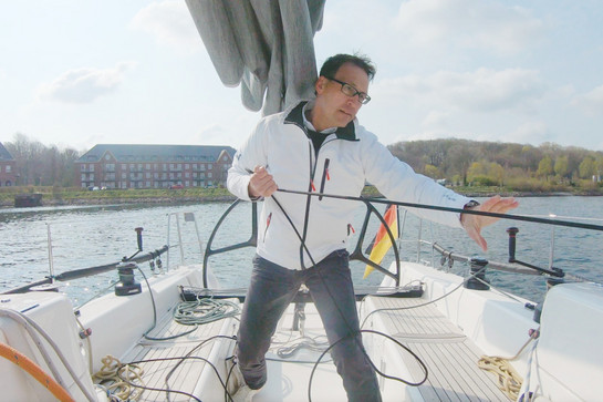 Zu sehen ist Testimonial Sven Christensen bei der Arbeit auf einem Segelboot.