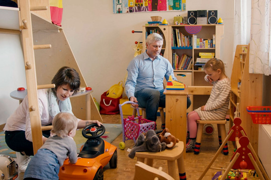 Zwei Personen spielen mit zwei Kindern