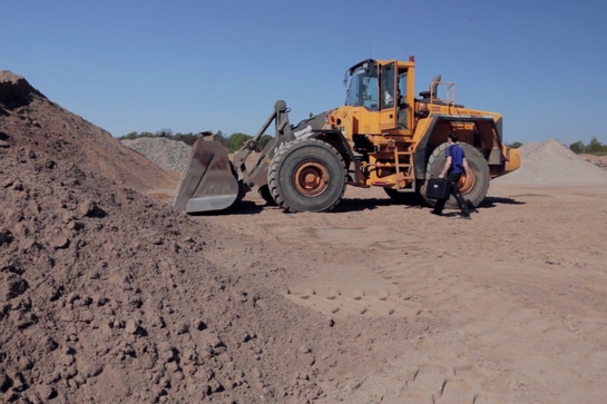Ein gelber Bagger auf der Baustelle