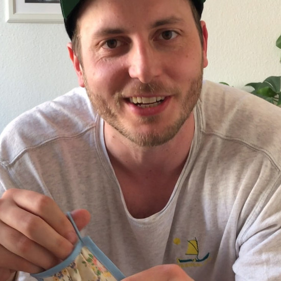 Richtiger Schutz im Nahverkehr Lars hält eine geblümte Maske in der Hand