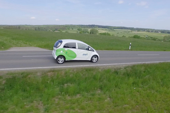 Ein weißes E Auto fährt auf einer Landstraße