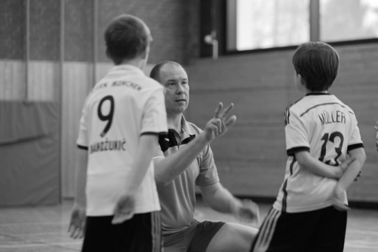 Ein Fußballtrainer spricht mit seinen Kindern
