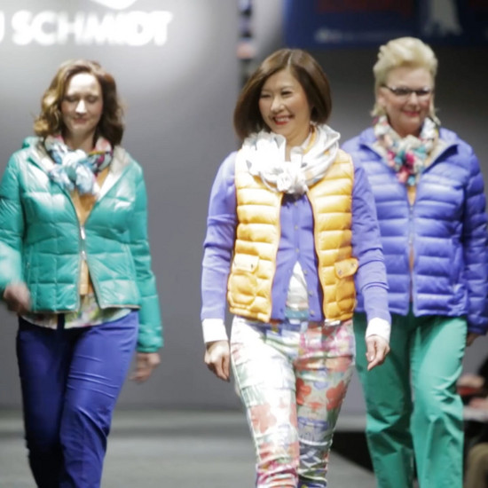 Drei Models gehen über einen Laufsteg