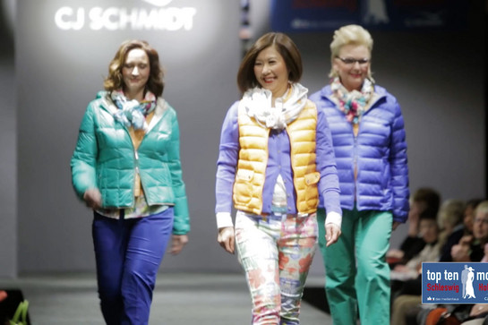 Drei Models gehen über einen Laufsteg