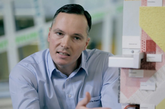 Ein Jacob Cement Mitarbeiter zeigt eine Beispieltafel
