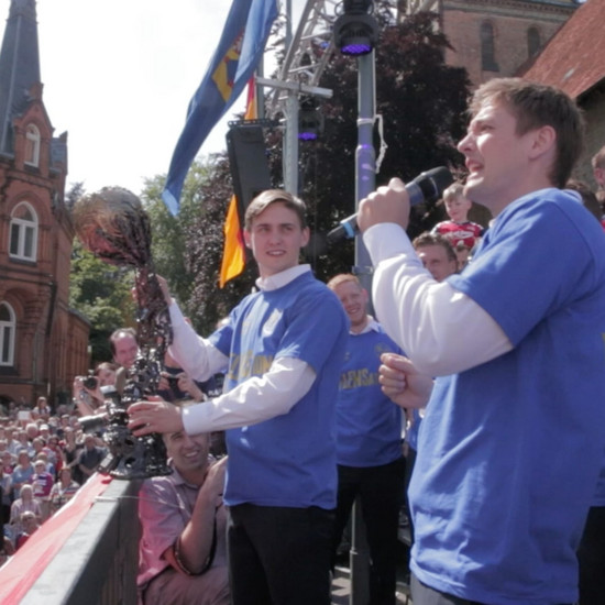 SG Spieler stehen auf einer Bühne am Südermarkt in Flensburg