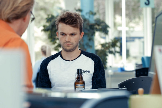 Ein Mann sitzt im Rathaus mit einem Bier