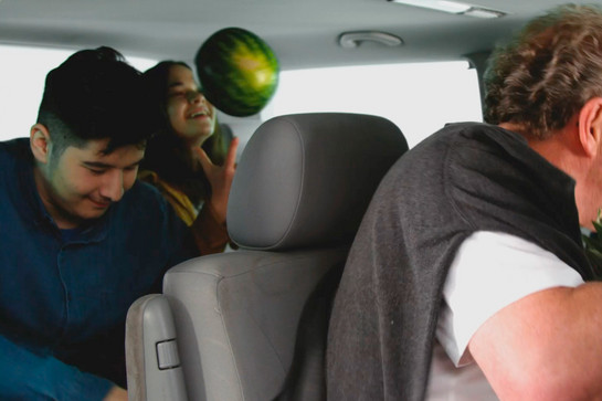 Ein Mädchen wirft eine Wassermelone in die Luft