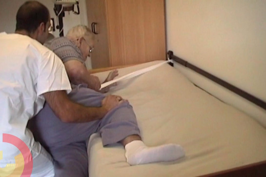 bb_webclips_teaser_05.jpg Ein Pfleger hilft einer Pflegebedürftigen Frau ins Bett