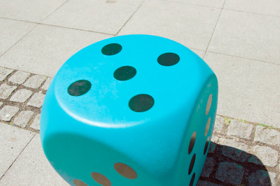 Ein großer blauer Würfel liegt auf dem asphalt