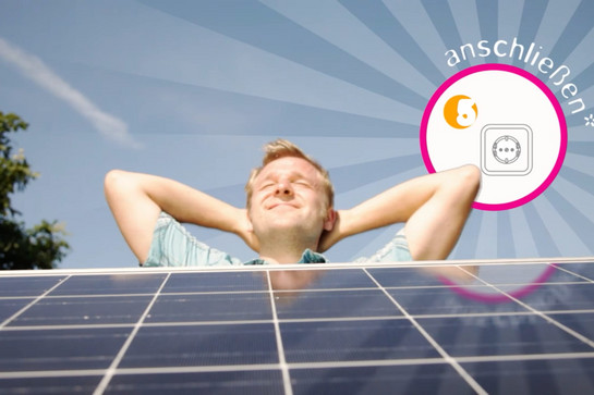 Ein Mann sitzt vor einer Solaranlage