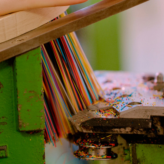 Eine Maschine kürzt die Borsten eines Besens