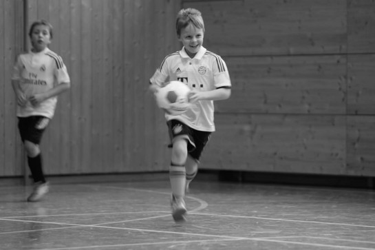 Ein Kind läuft mit einem Fußball in der Hand