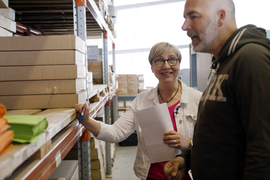 York geht mit einer futura Mitarbeiterin durch das Logistik Zentrum