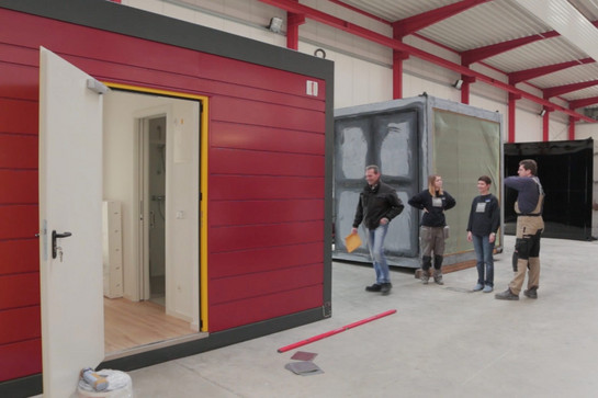 Vier Bauarbeiter stehen vor einer Smartlodge
