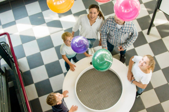 Bunte Ballons fliegen in einem Raum rum