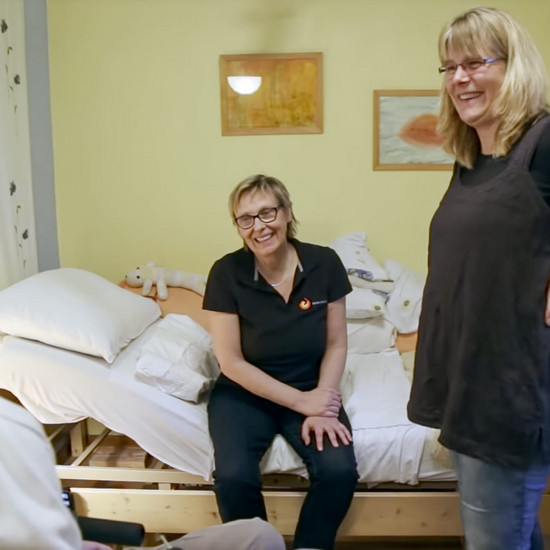 Zwei Personen sitzen auf einem Bett